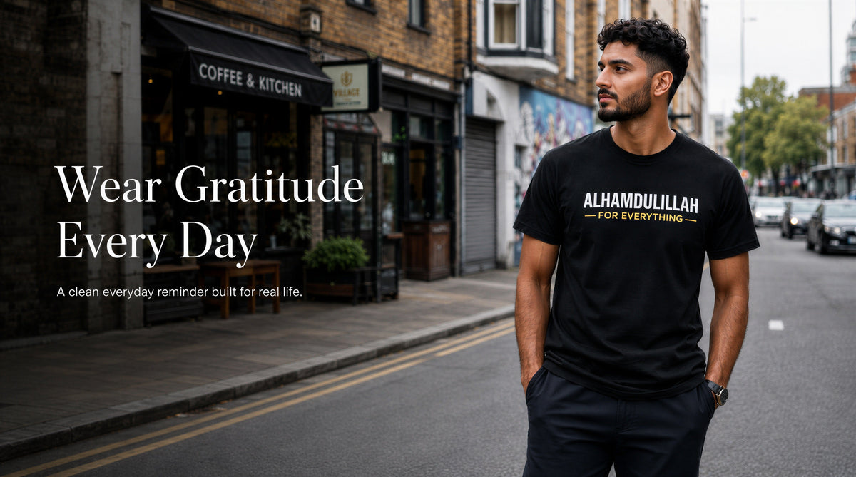Man wearing a black t-shirt with 'ALHAMDULILLAH FOR EVERYTHING' text on a street.slider_item_TrdfeX